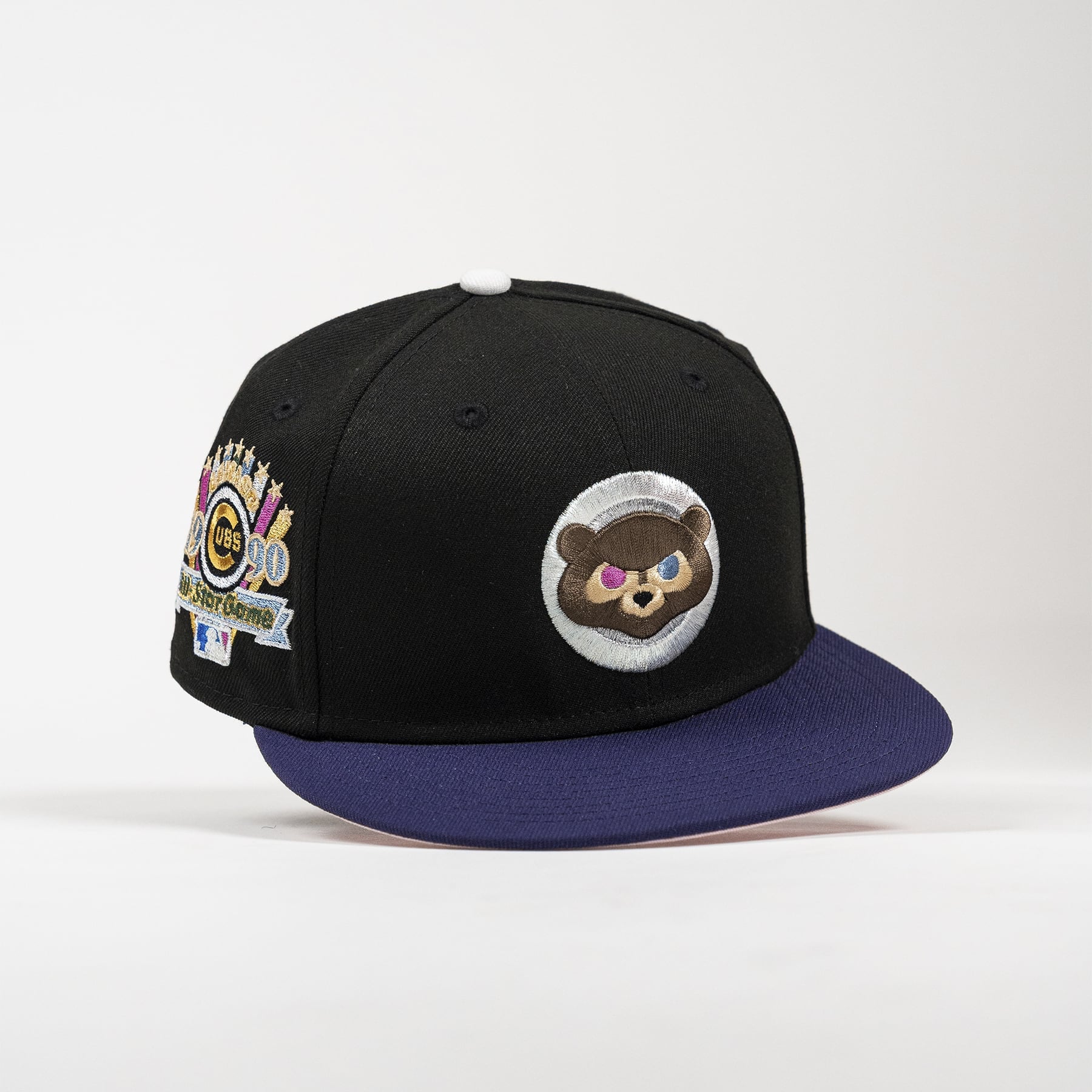 A black flat-brim baseball cap with a dark purple brim, featuring a circular embroidered brown bear patch on the front and a colorful '2020 World Series' patch on the side.