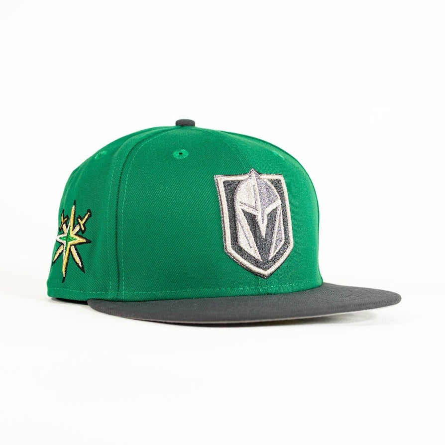 A green Las Vegas Vegas Golden Knights snapback cap with a dark gray flat brim, featuring the team's shield logo on the front and a gold and green starburst patch on the side, set against a plain white background.