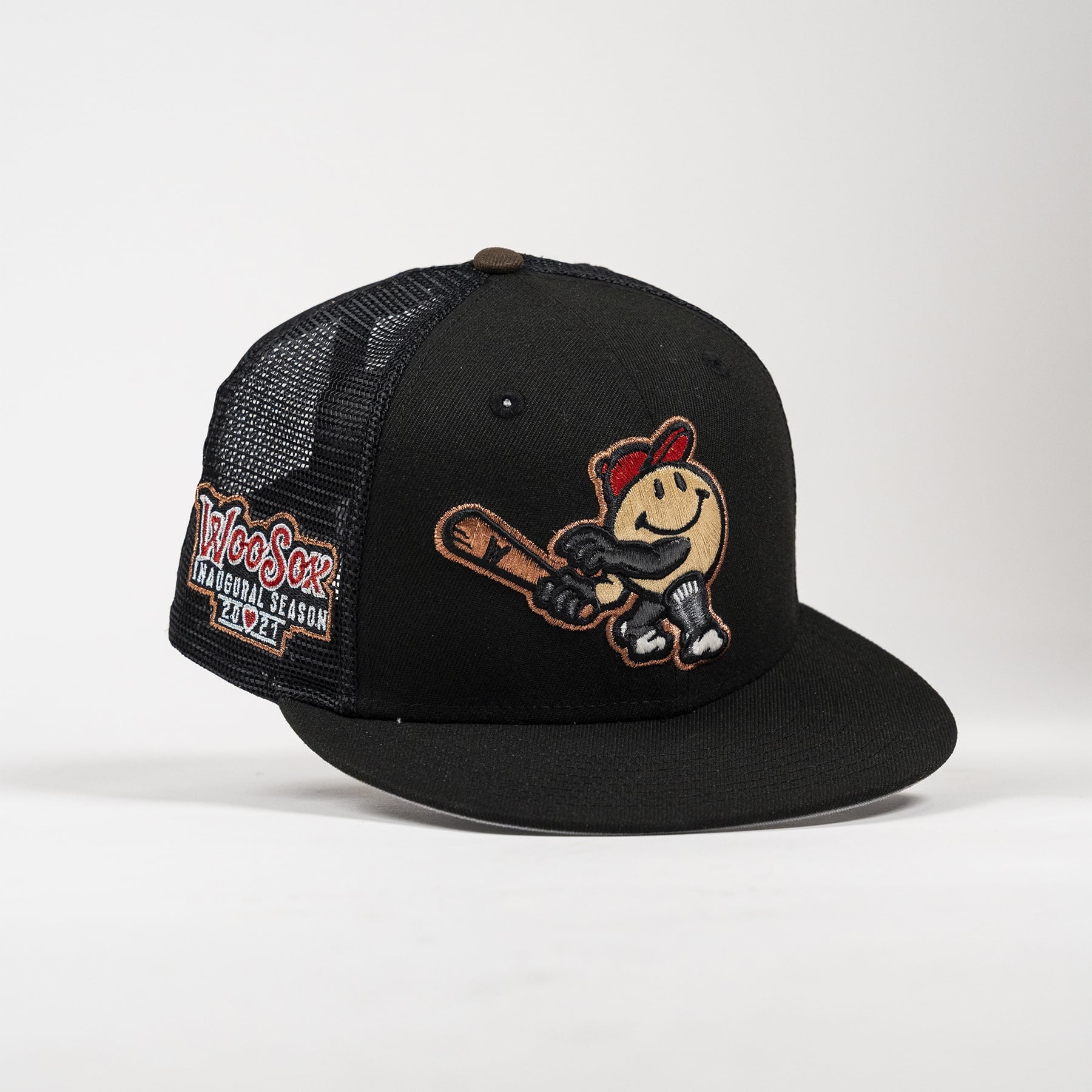 A black trucker-style baseball cap with a mesh back, featuring an embroidered cartoon smiley face holding a bat on the front and a 'WooSox All-Star Season 2025' patch on the side.