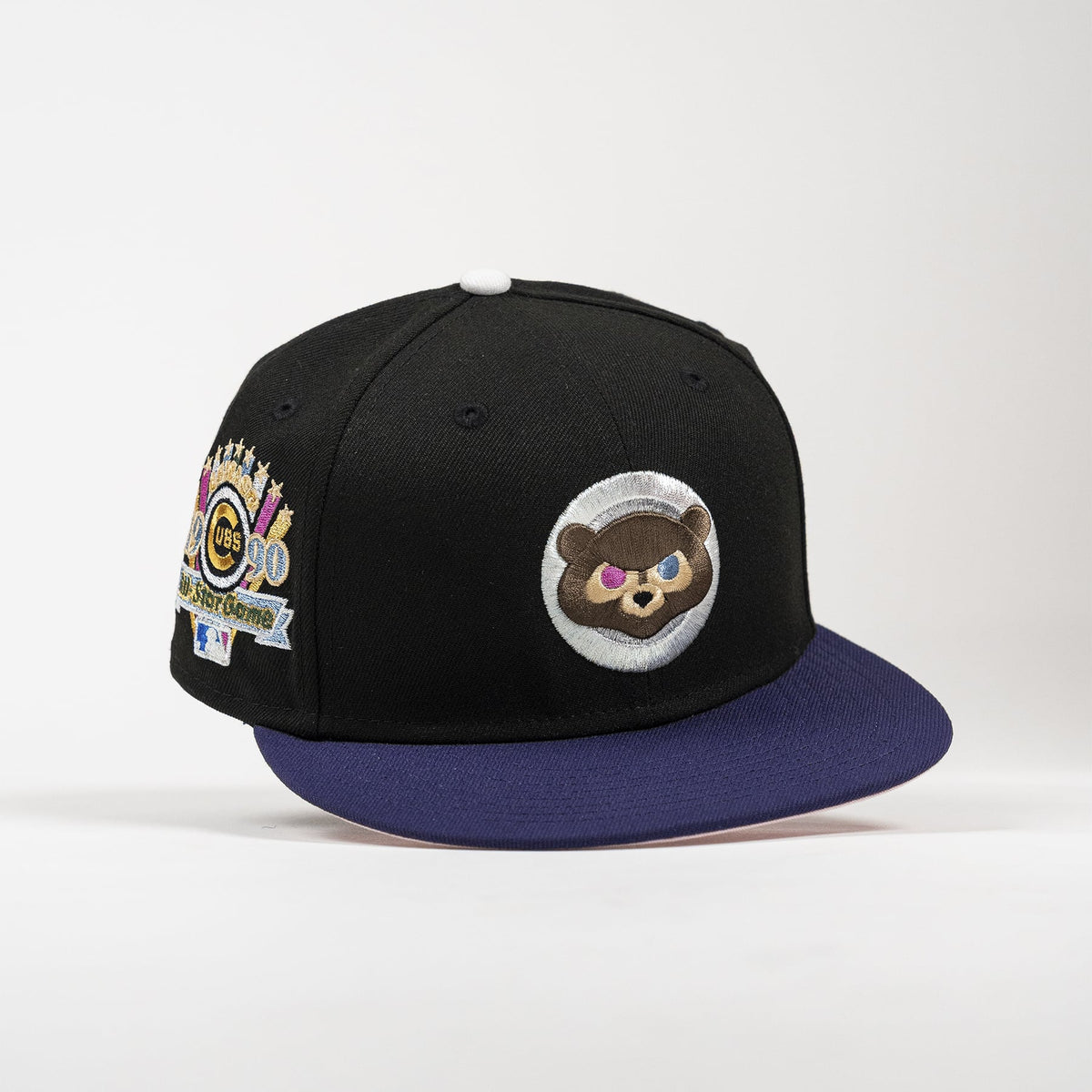 A black flat-brim baseball cap with a dark purple brim, featuring a circular embroidered brown bear patch on the front and a colorful '2020 World Series' patch on the side.