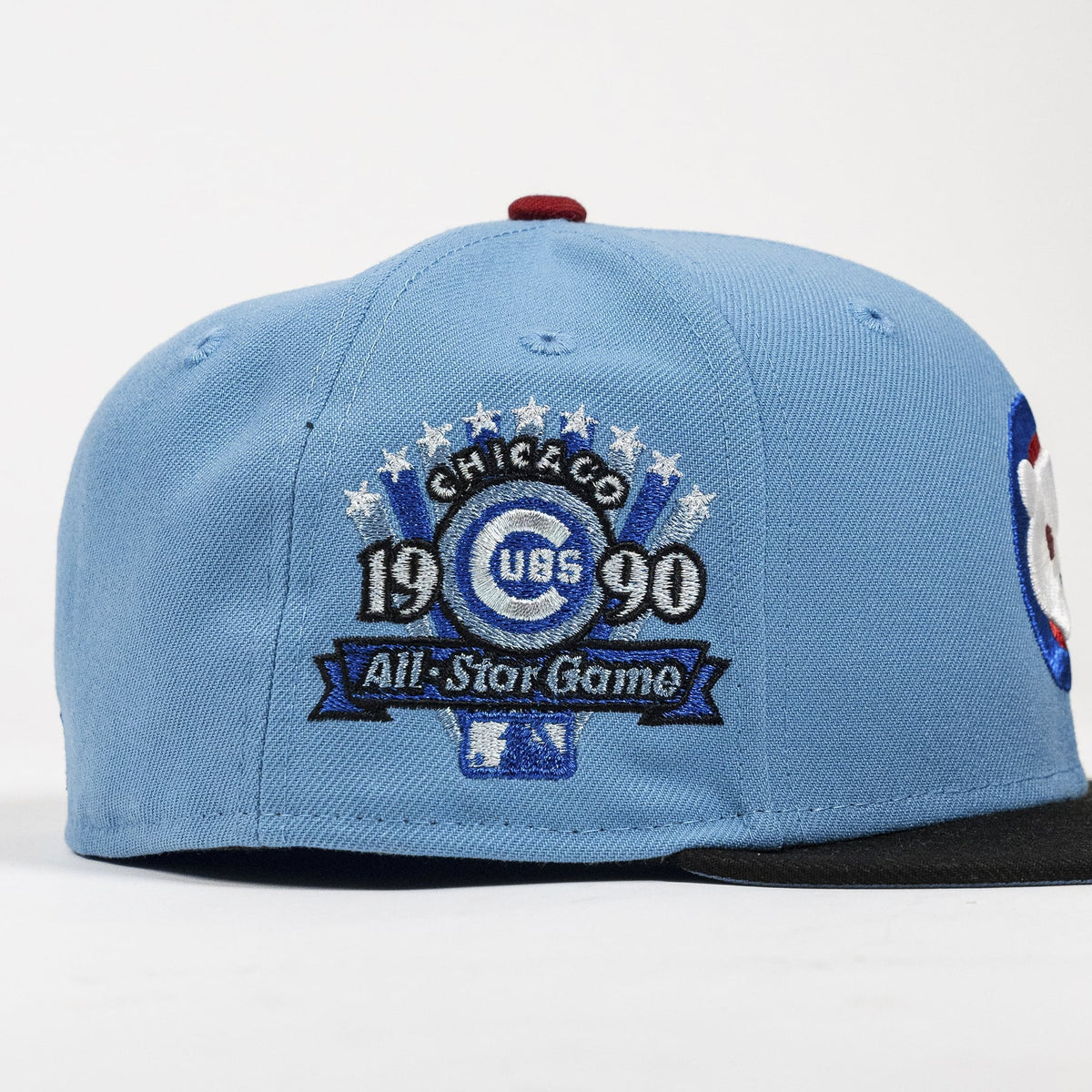 A light blue baseball cap featuring a prominent embroidered Chicago Cubs 1990 All-Star Game patch on the front, with a black brim and a red button on top.