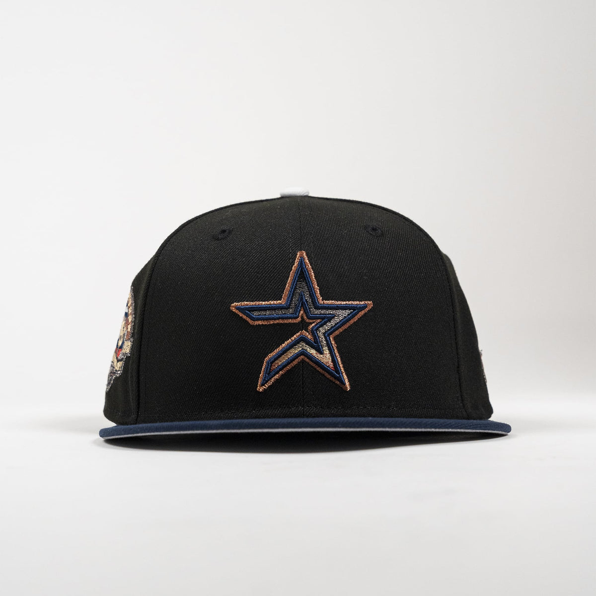 A black Dallas Cowboys snapback cap featuring a large embroidered star logo on the front with navy and gold details, set against a plain light gray background.
