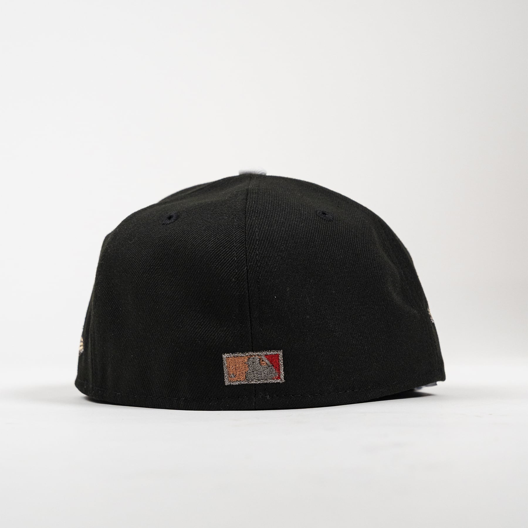 A black structured baseball cap shown from the back, featuring a small rectangular embroidered patch on the center back with a mountain graphic and the text '2400 MTS'.