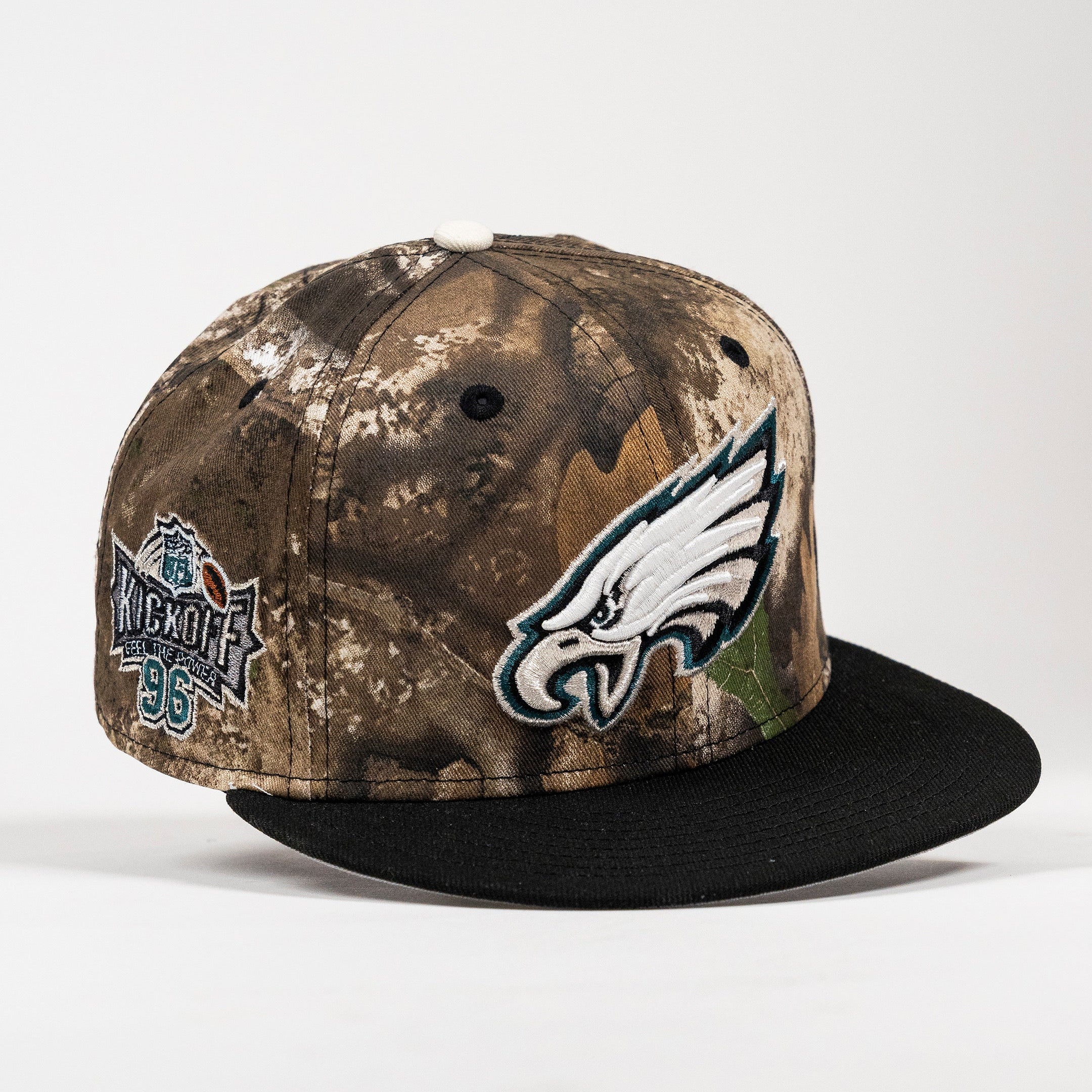 A Philadelphia Eagles 96 Kickoff snapback cap featuring a brown and beige woodland camouflage pattern, a black flat brim, the Philadelphia Eagles logo on the front, and a 35th Anniversary patch on the side.