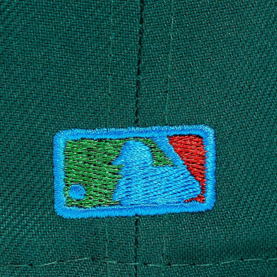 Close-up of a green cap with a embroidered logo on a green background
