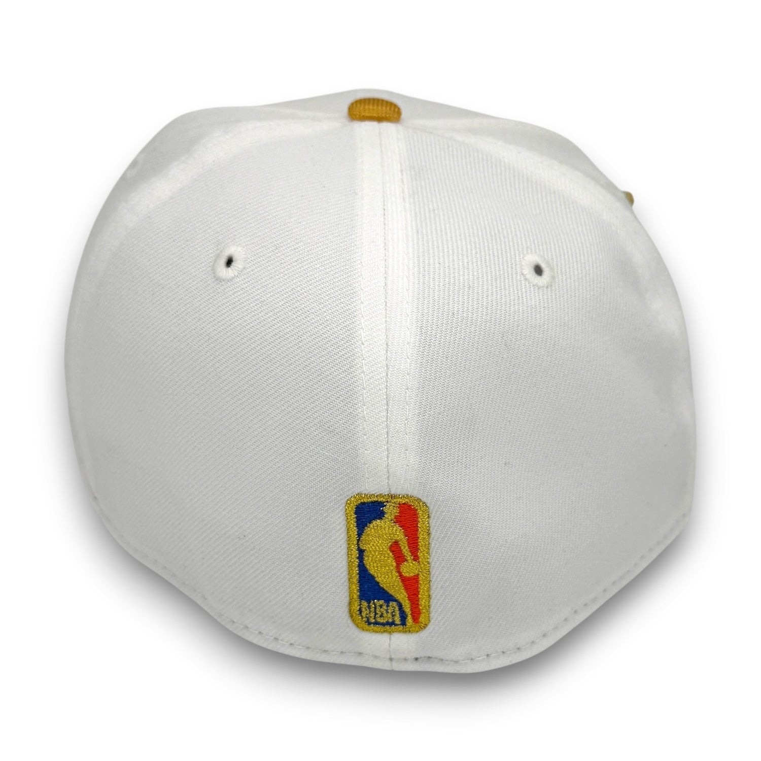 White structured baseball cap with a gold button on top and an embroidered NBA logo patch on the front, shown against a plain white background.