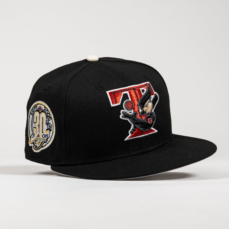 A black flat-brim snapback cap featuring a large red and black embroidered 'T' patch with a cartoon character on the front, and a circular '30th Season' patch on the side, set against a light gray background.