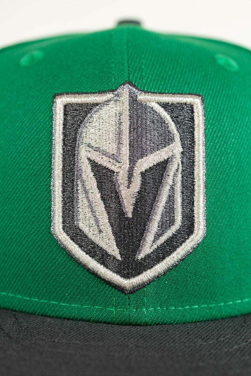 A close-up of a green and black baseball cap featuring an embroidered Las Vegas Vegas Golden Knights hockey shield logo on the front.