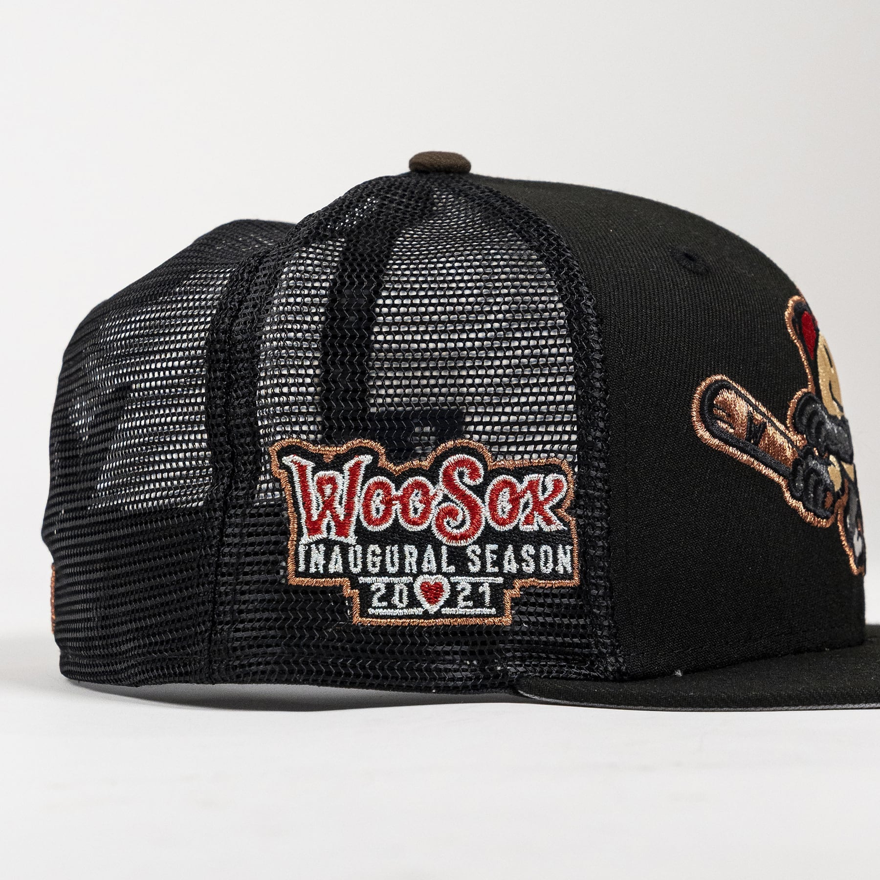 Black trucker-style baseball cap with a black mesh back, featuring an embroidered 'Woo Sox Inaugural Season 2021' patch on the front and a large embroidered mascot patch on the side.